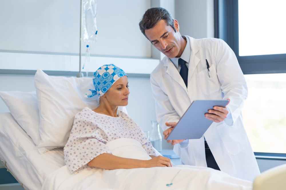 woman in hospital bed reviewing chart with doctor